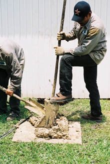 After the bellling tool is removed from the hole the workers open the flanges and remove the soil.