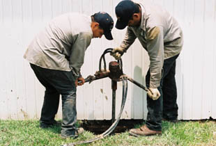 Drilling nine inch holes requires two men to manage the hydraulic drilling equipment.