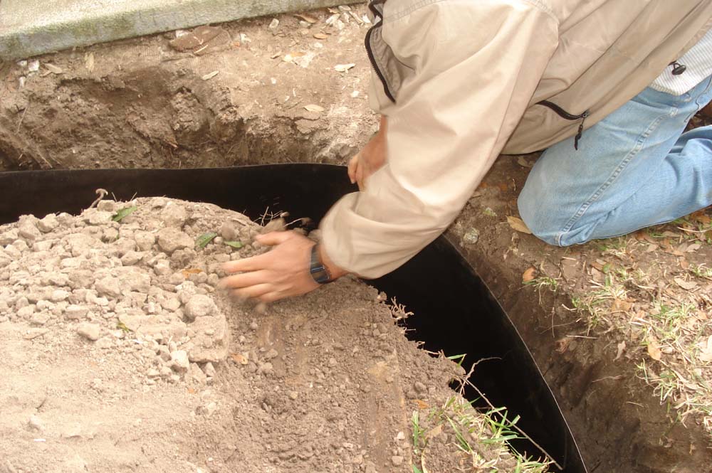 The soil back fill process begins for the root barricade - Plano Foundation Repair