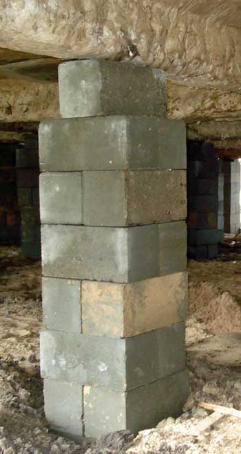 Photo of a column of concrete blocks used to support a house that has been elevated approximately five feet.