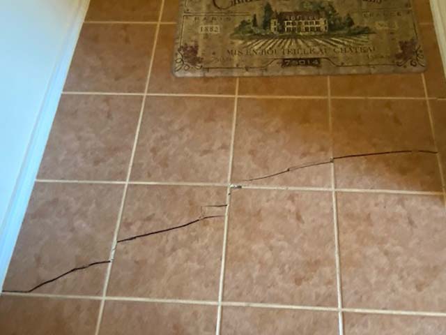 Tile floors cracked after soil movement damaged home's concrete slab foundation