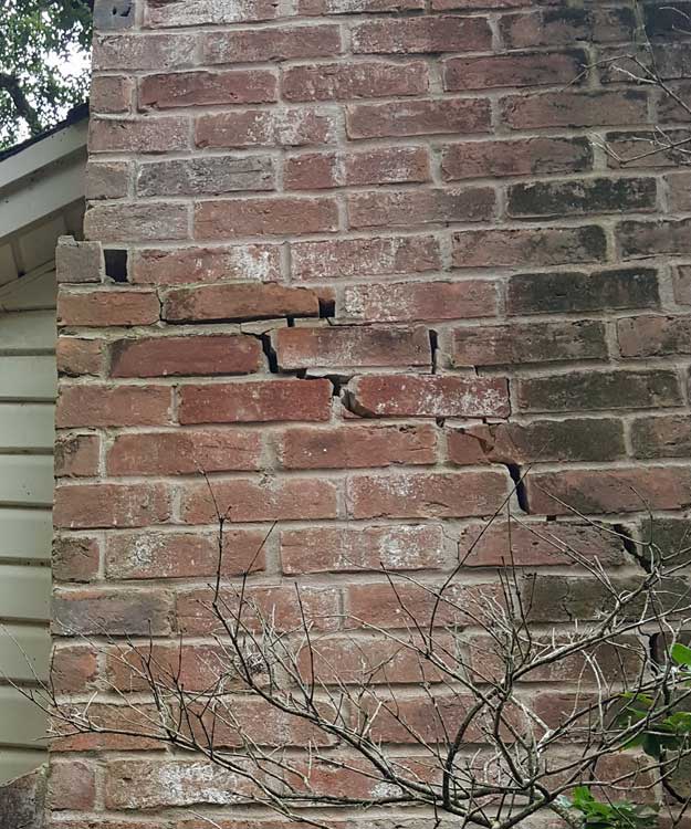 Soil movement has cracked the home's slab foundation and resulted in additional damage to the home's exterior brick wall and fireplace.